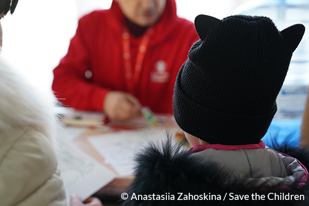 CH1959857_Serhii,-Save-the-Children-worker-is-playing-with-a-child-in-the-childrens-corner-at-the-cash-assistance-registration-site-(Dnipro,-East-Ukraine)